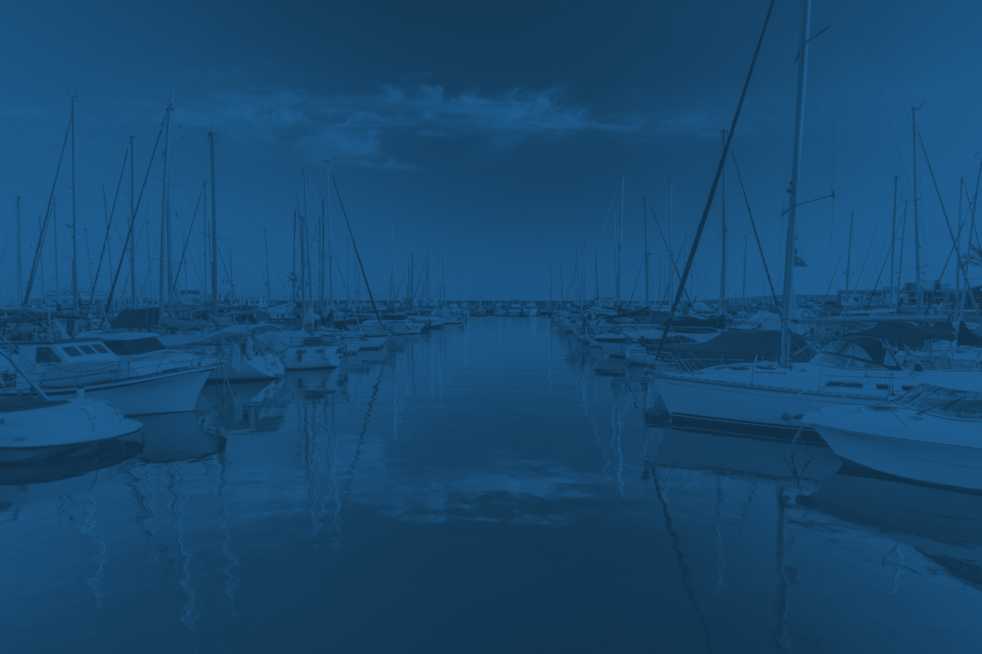 Boats in a harbor with a blue tinge.